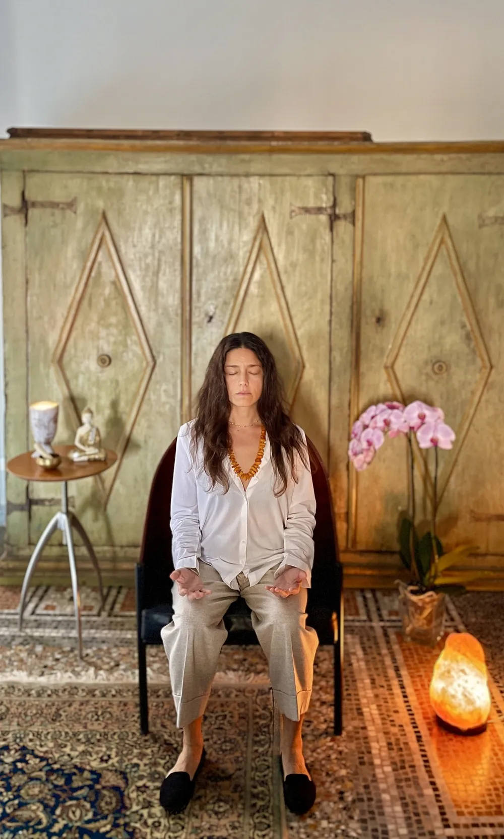 Gaia Calamai in meditazione seduta su una sedia nel suo studio a Firenze